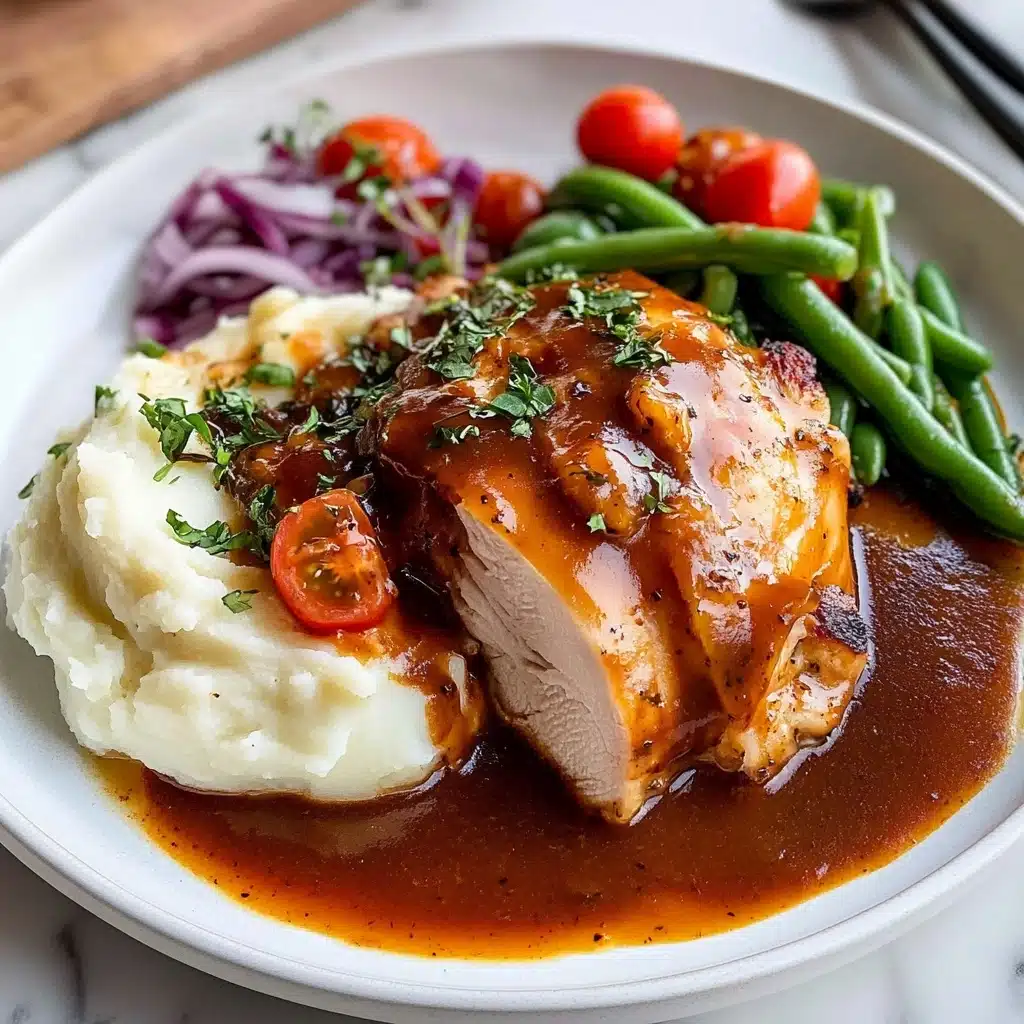 Oven Baked BBQ Chicken, homemade barbecue sauce, juicy baked chicken, easy BBQ chicken recipe, family dinner ideas A white round plate holds a meal with three main parts: on the left, there is a thick layer of white mashed potatoes with a smooth texture and a splash of orange-colored sauce. In the middle, a large piece of meat covered in dark brown sauce with a shiny, slightly thick texture, sprinkled with small green herbs, sits partly over the mashed potatoes. On the right, the meat is sliced to show its tender layers, resting in more sauce that spreads across the plate's surface. Behind the meat, there are fresh green beans topped with red cherry tomato halves and finely chopped purple onions, adding a fresh and colorful touch to the dish. The background shows a white marbled texture.