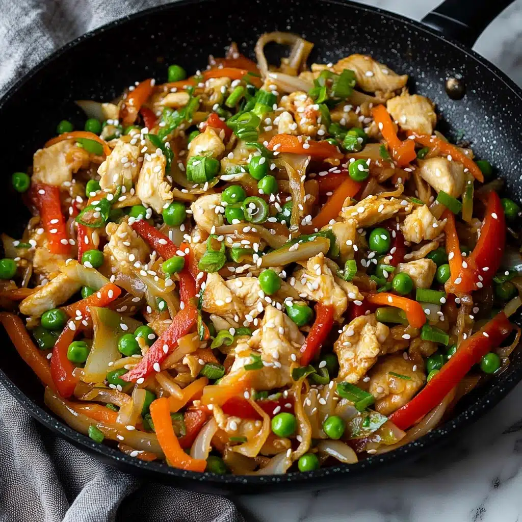Chicken and Cabbage Stir Fry, easy chicken stir fry, healthy cabbage stir fry, quick weeknight dinner recipes, flavorful stir fry dishes The image shows a white bowl filled with a colorful stir-fry dish placed on a white marbled surface. Inside the bowl, there are visible layers including bright green peas, light orange carrot strips, soft golden tan chicken pieces, translucent white onion slices, and red bell pepper slices, all mixed together and sprinkled with white sesame seeds and chopped green onions on top. Black chopsticks are placed inside the bowl, touching the food. Next to the bowl is a black pan containing more of the same stir-fry mix with peas, onions, carrots, and chicken. The overall texture of the food is glossy and fresh.