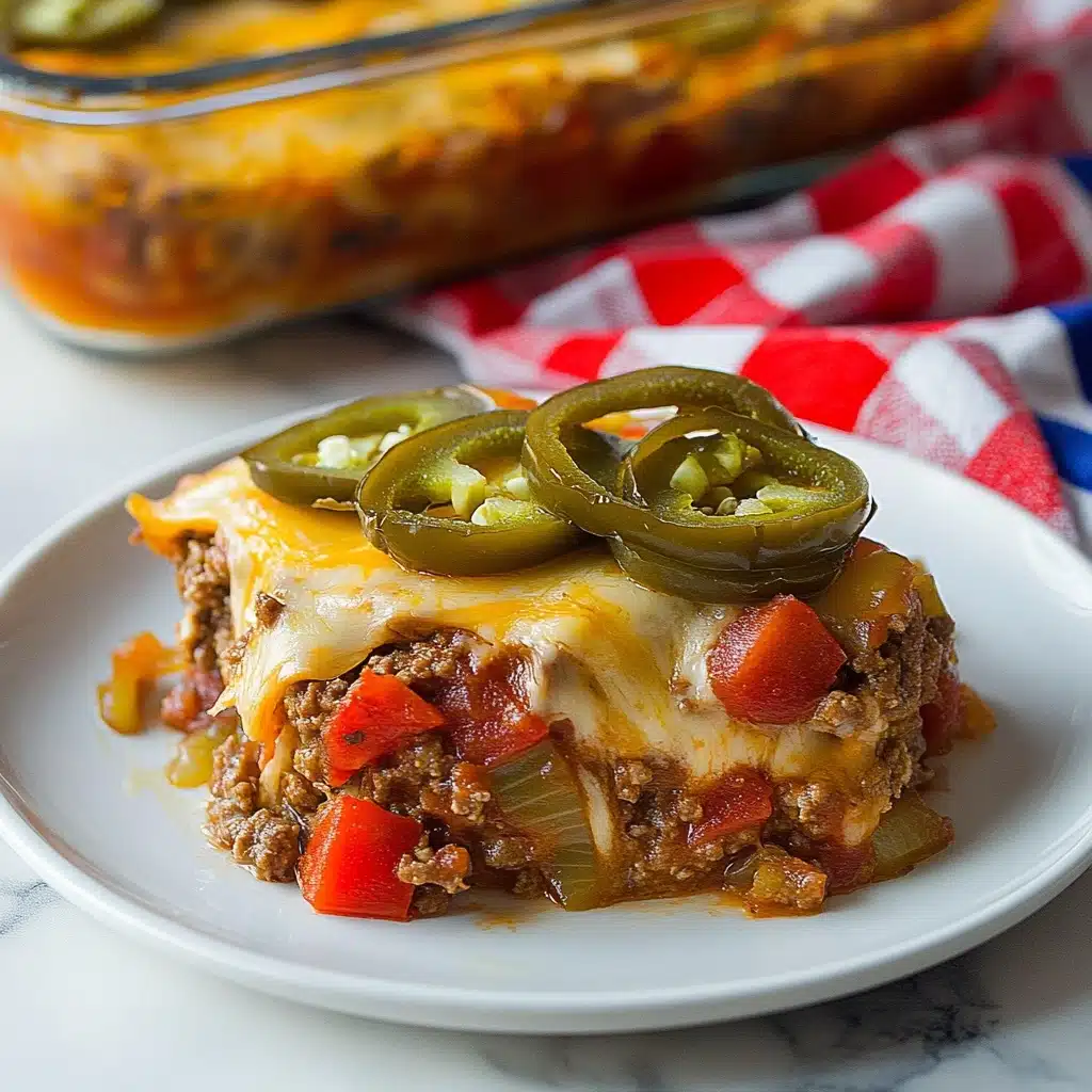 Southern Five Layer Beef Casserole, Layered Beef Casserole Recipe, Easy Southern Beef Casserole, Comfort Food Beef Casserole, Hearty Beef Bake A white plate holds a layered dish with three main layers visible. The bottom layer is ground meat mixed with diced red bell peppers and translucent cooked onions, giving a mix of dark brown and bright red with some light brown tones. The middle layer is a light-colored melted cheese that covers the meat mixture unevenly. The top layer is sliced green jalapeños, slightly cooked, placed closely in a row across the dish. The plate sits on a white marbled surface with a red, white, and blue checkered cloth beneath it. In the background, there is a clear rectangular baking dish with the same layered food inside.