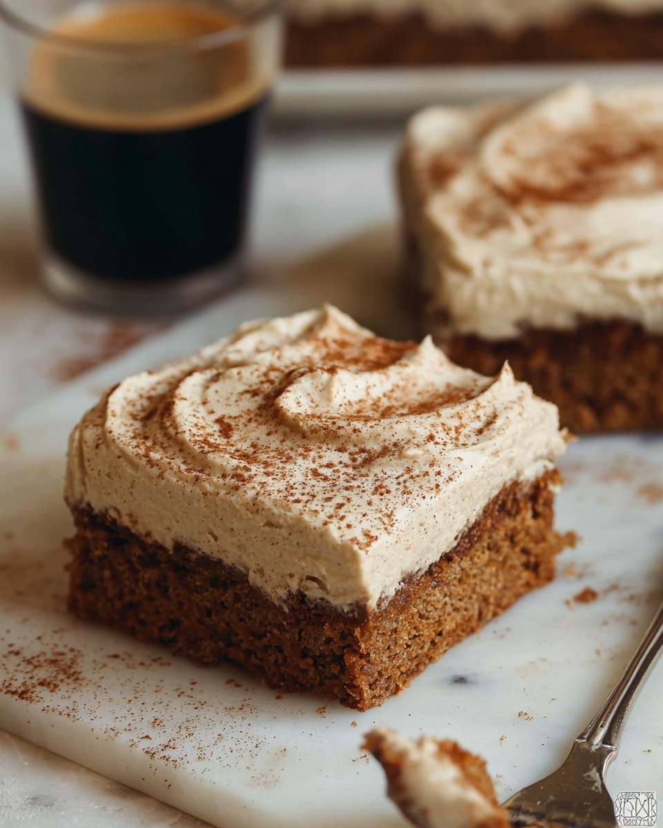 The image shows a close-up of a square piece of cake with two clear layers. The bottom layer is a moist, medium brown sponge cake with a slightly rough texture. The top layer is thick, creamy frosting with a light beige color dotted with tiny brown specks, spread smoothly but with some swirled patterns. The cake piece is placed on a white marbled surface with cinnamon sticks partially visible nearby. Other similarly frosted cake pieces are seen blurred in the background. photo taken with an iphone --ar 4:5 --v 7
